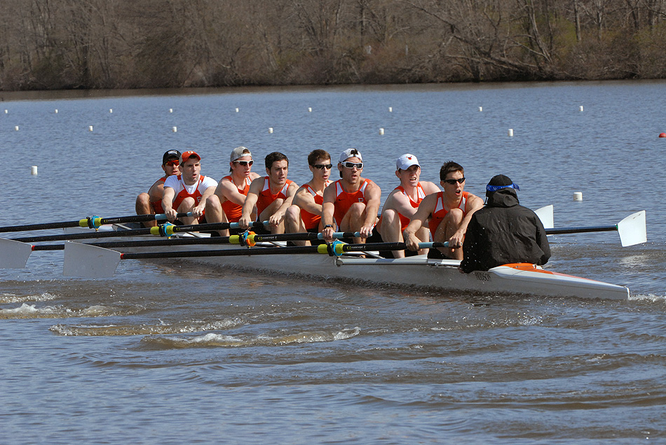 A group of people rowing a boat in a body of water