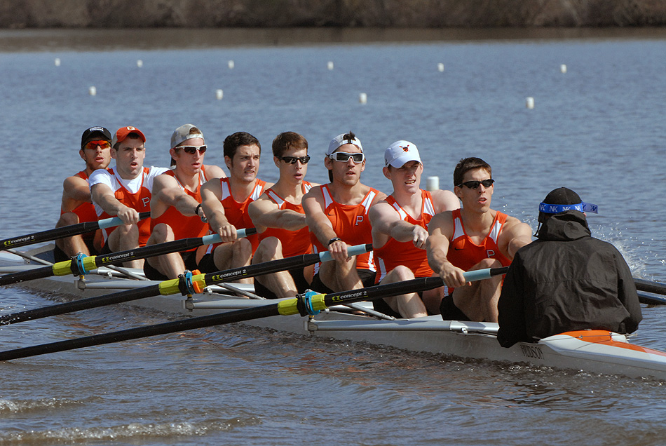 A group of people rowing a boat in a body of water