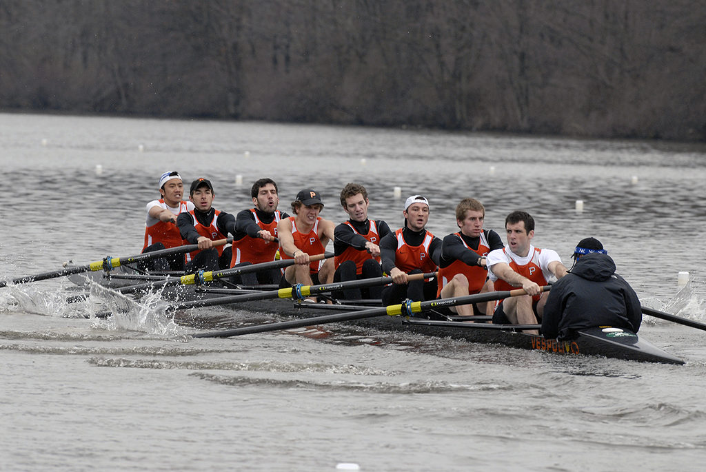 A group of people rowing a boat in the water