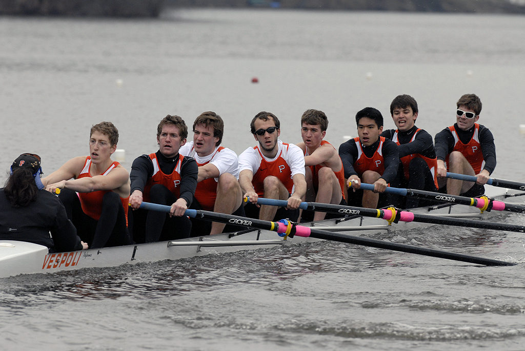 A group of people rowing a boat in the water