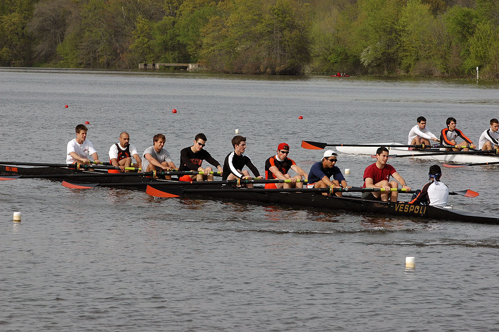 A group of people rowing a boat in a body of water