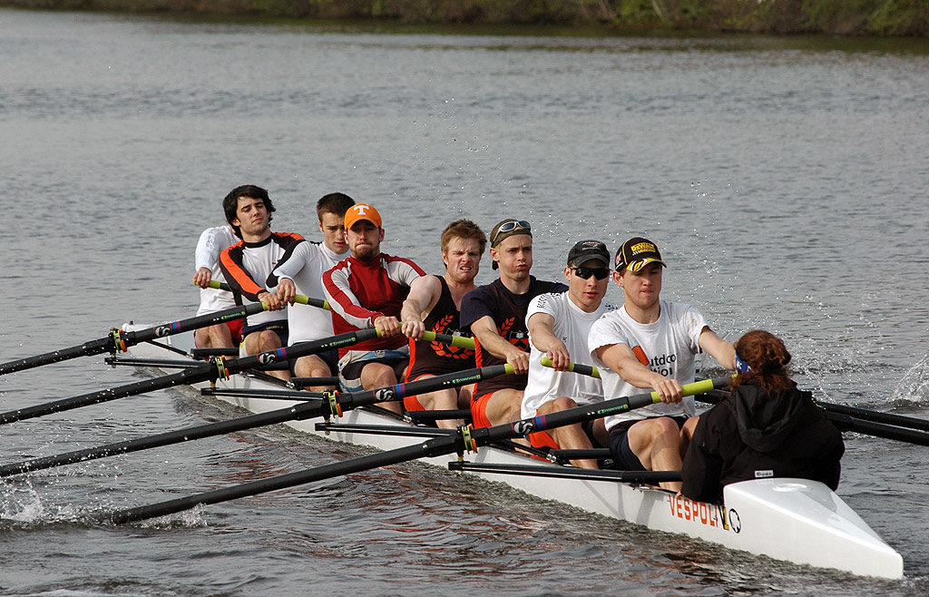 A group of people rowing a boat in the water