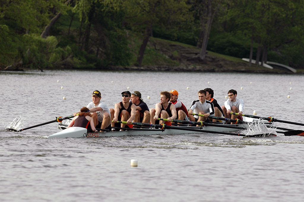 A group of people rowing a boat in a body of water