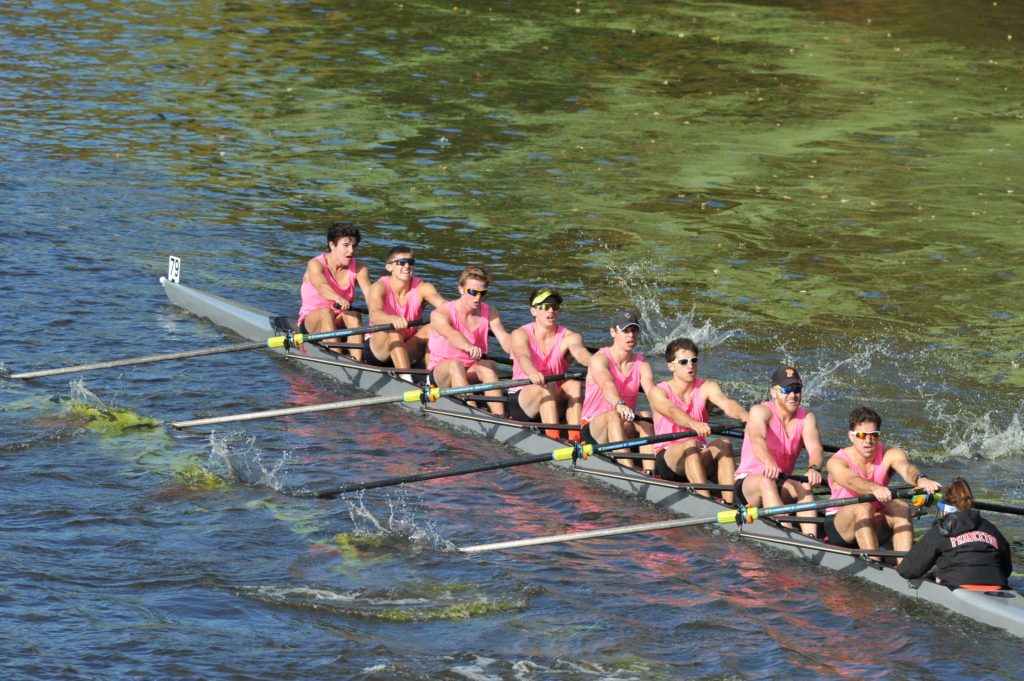 A group of people rowing a boat in the water