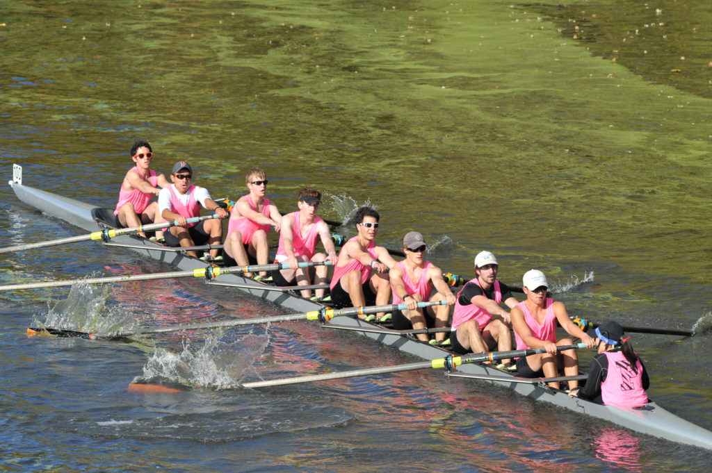 A group of people rowing a boat in the water