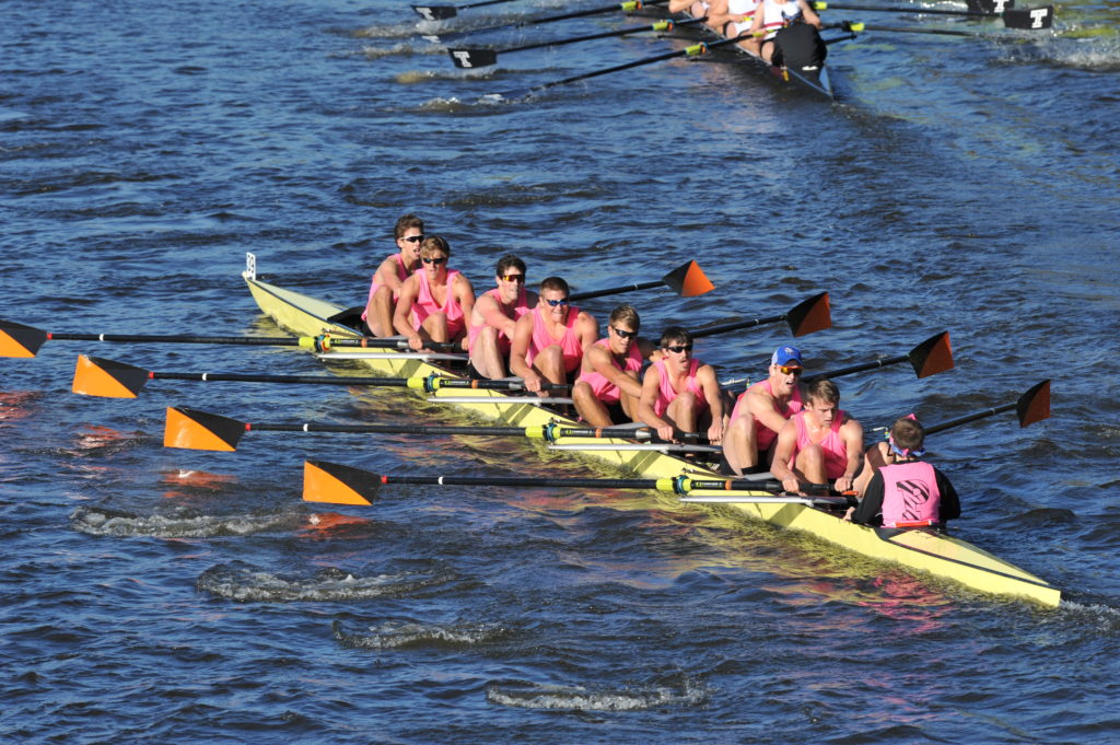 A group of people rowing a boat in a body of water