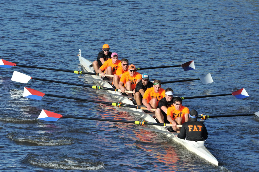 A group of people rowing a boat in a body of water