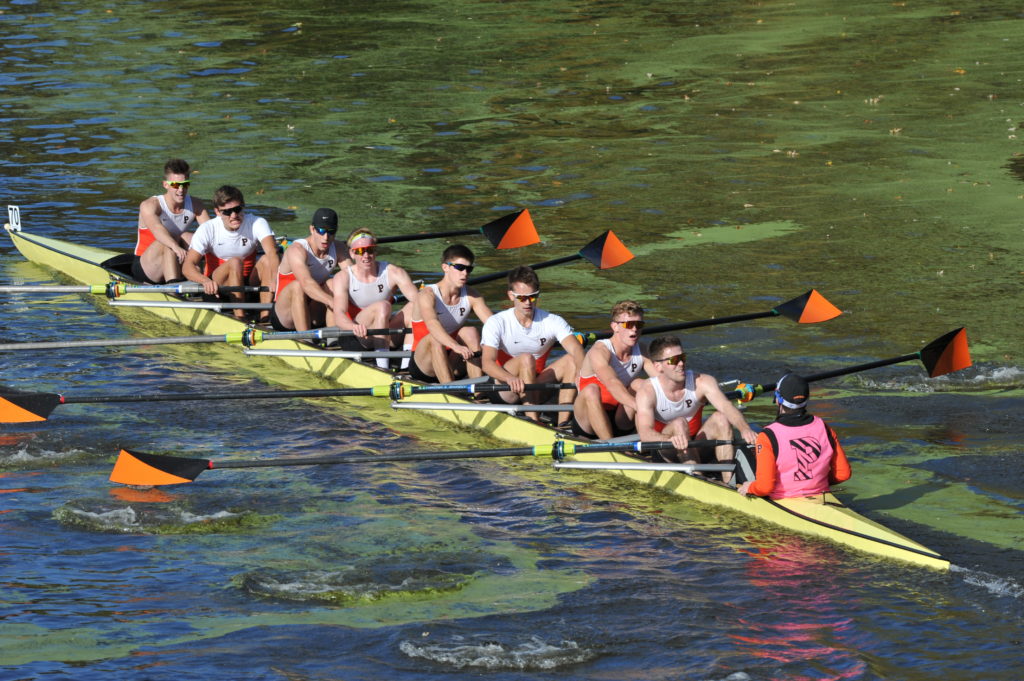 A group of people rowing a boat in the water