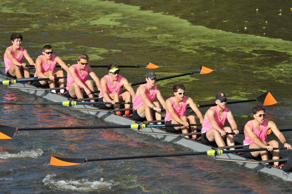 A group of people rowing a boat in the water