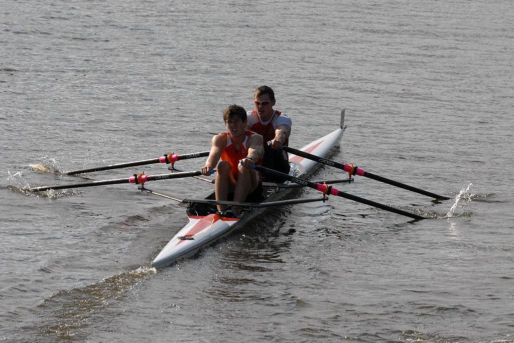 A group of people rowing a boat in the water