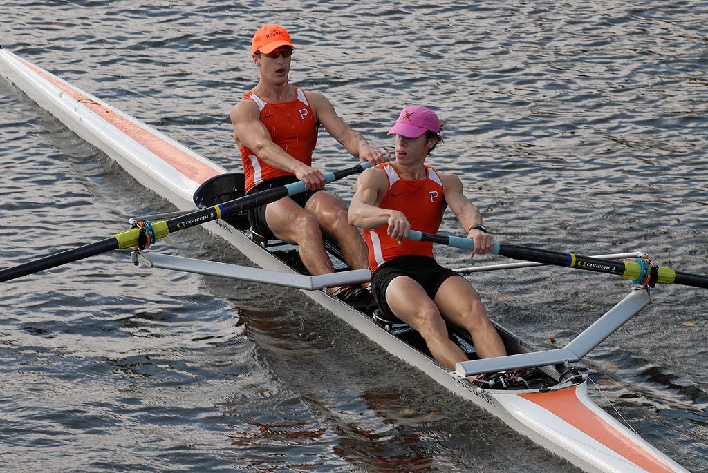 A group of people rowing a boat in the water