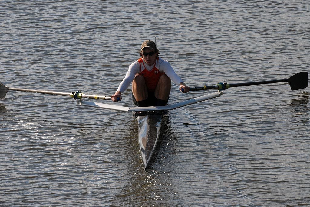 A man rowing a boat in a body of water