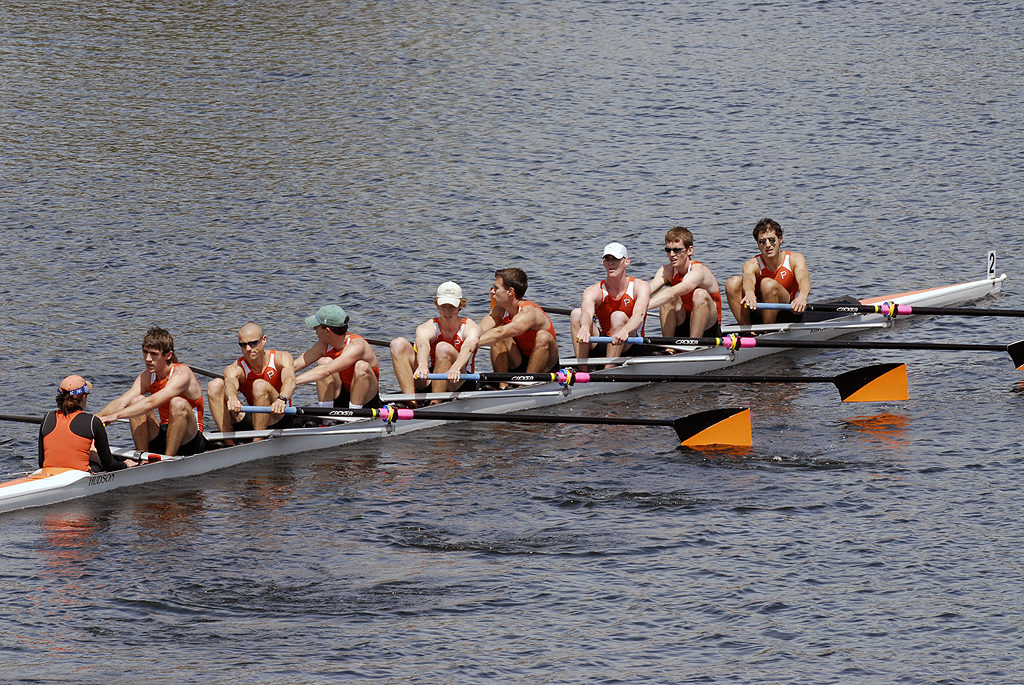 A group of people rowing a boat in the water