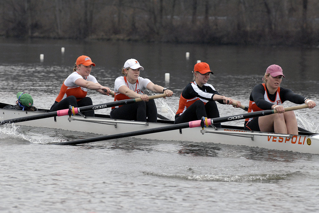 A group of people rowing a boat in the water