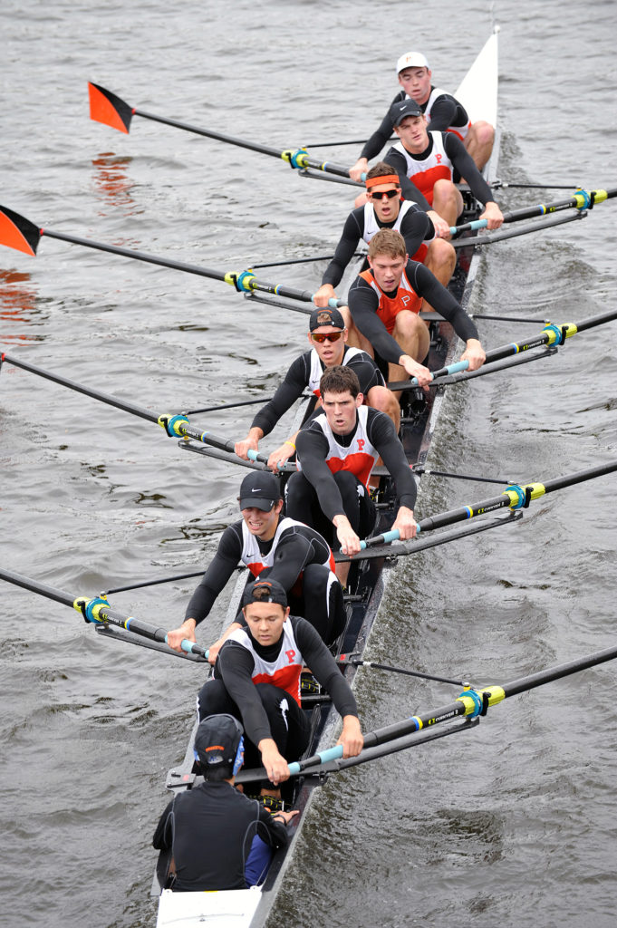 A group of people rowing a boat in the water