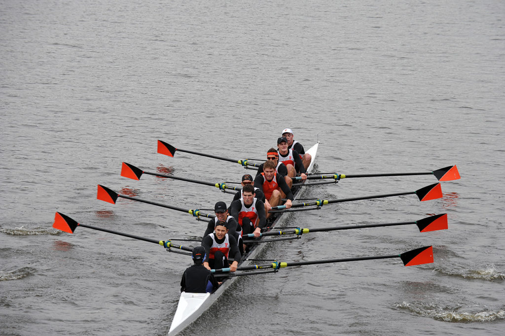 A group of people rowing a boat in the water