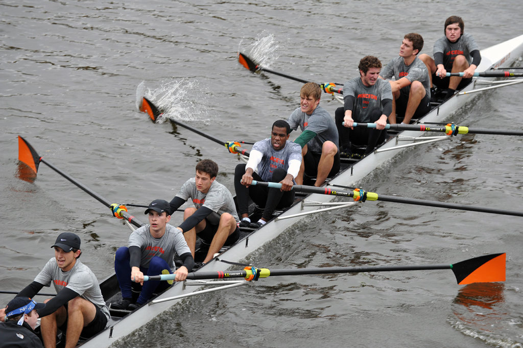 A group of people rowing a boat in the water