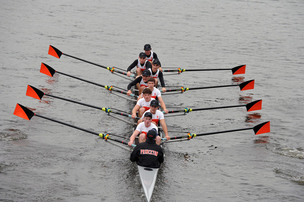 A group of people rowing a boat in the water