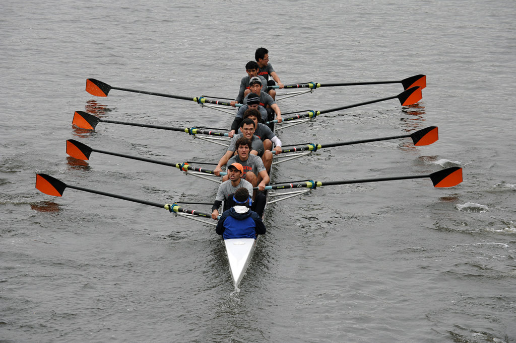 A group of people rowing a boat in the water