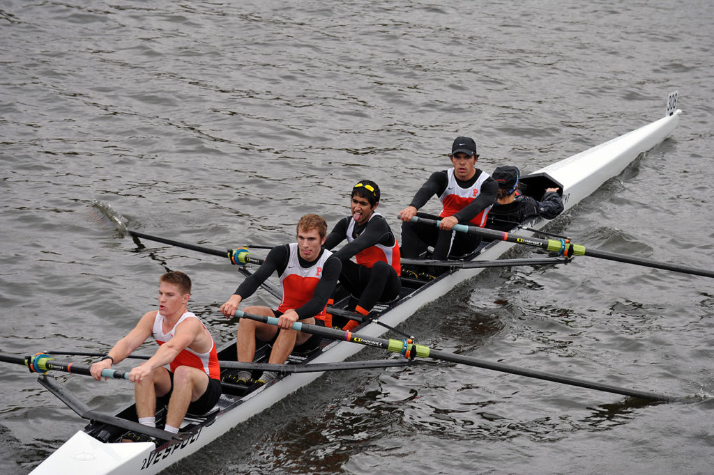 A group of people rowing a boat in the water