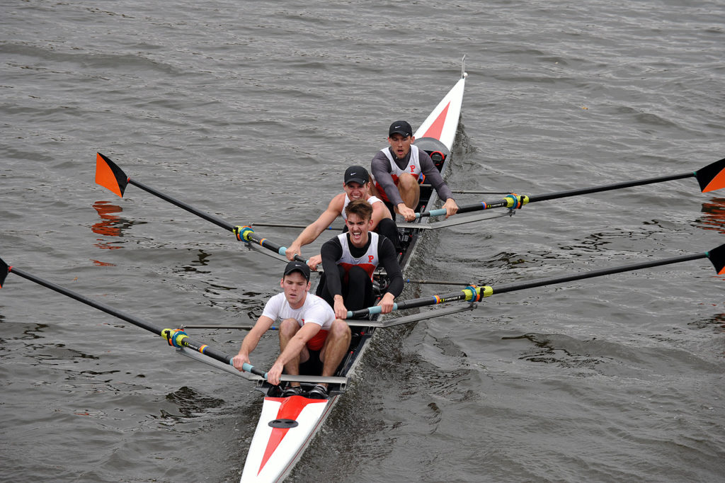 A group of people rowing a boat in the water