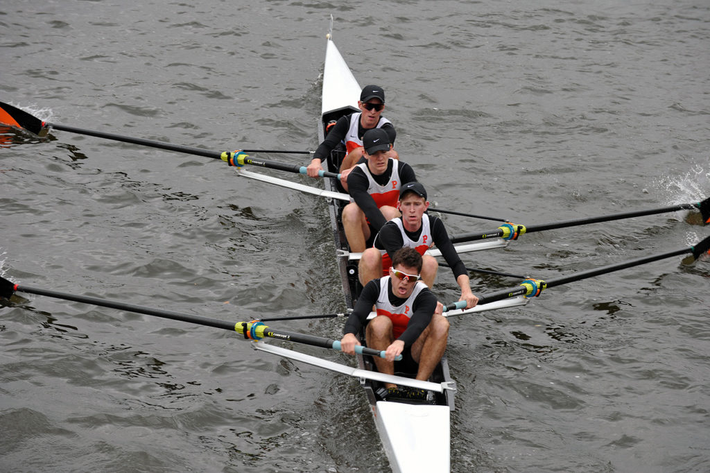 A group of people rowing a boat in the water