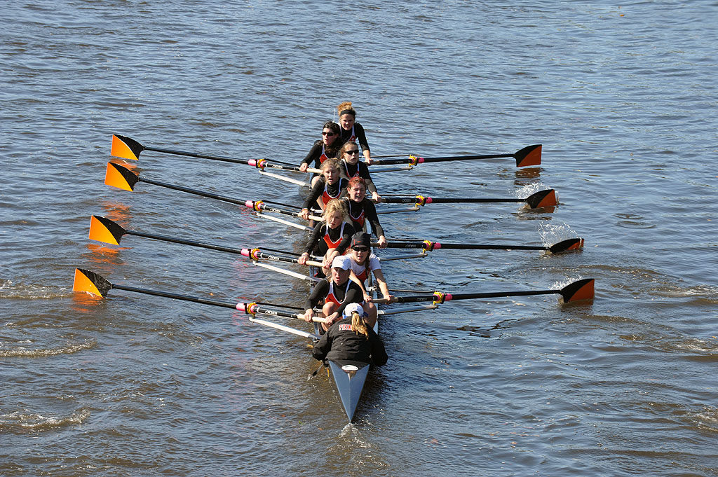 A group of people rowing a boat in the water