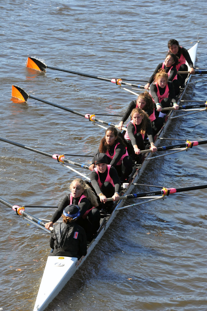 A group of people rowing a boat in a body of water