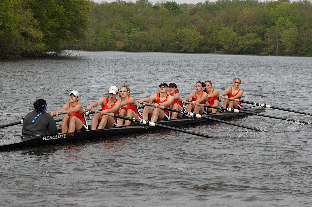 A group of people rowing a boat in a body of water