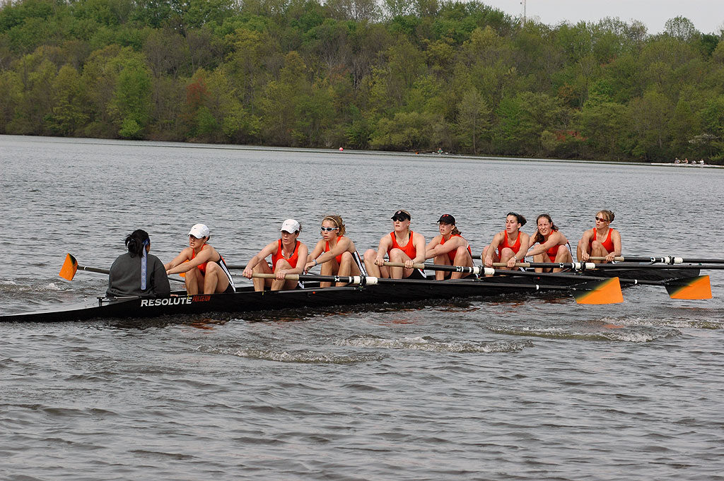 A group of people rowing a boat in a body of water