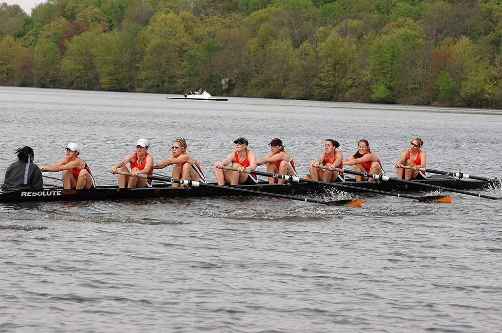 A group of people rowing a boat in a body of water