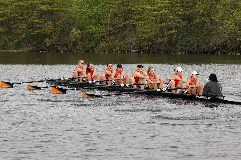 A group of people rowing a boat in a body of water