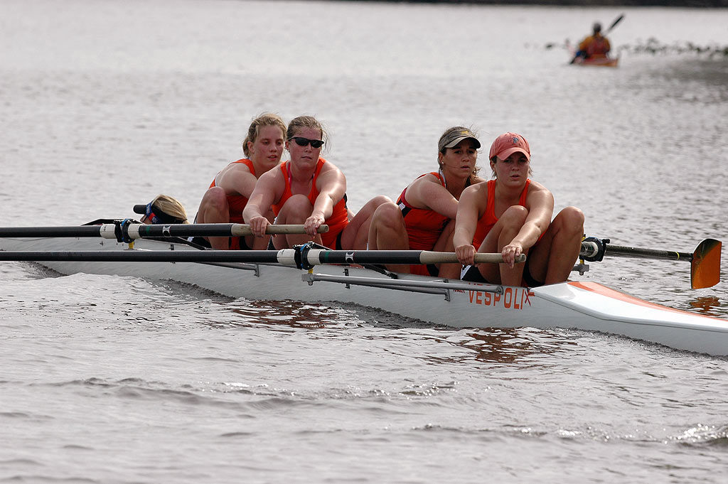 A group of people rowing a boat in the water