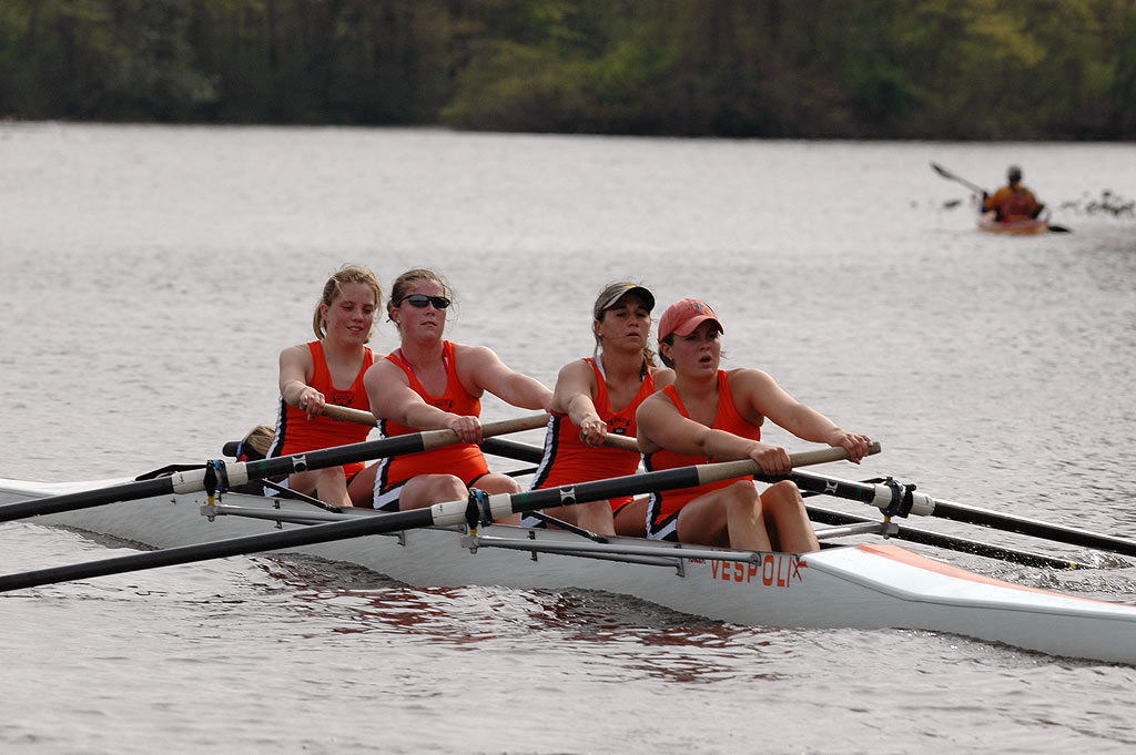 A group of people rowing a boat in the water