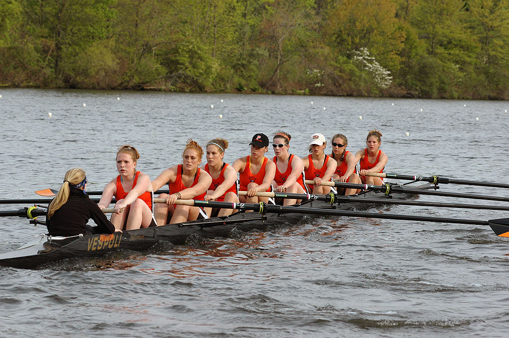 A group of people rowing a boat in a body of water