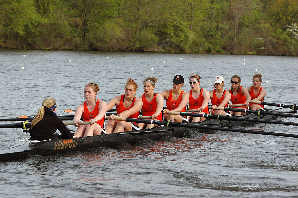 A group of people rowing a boat in a body of water