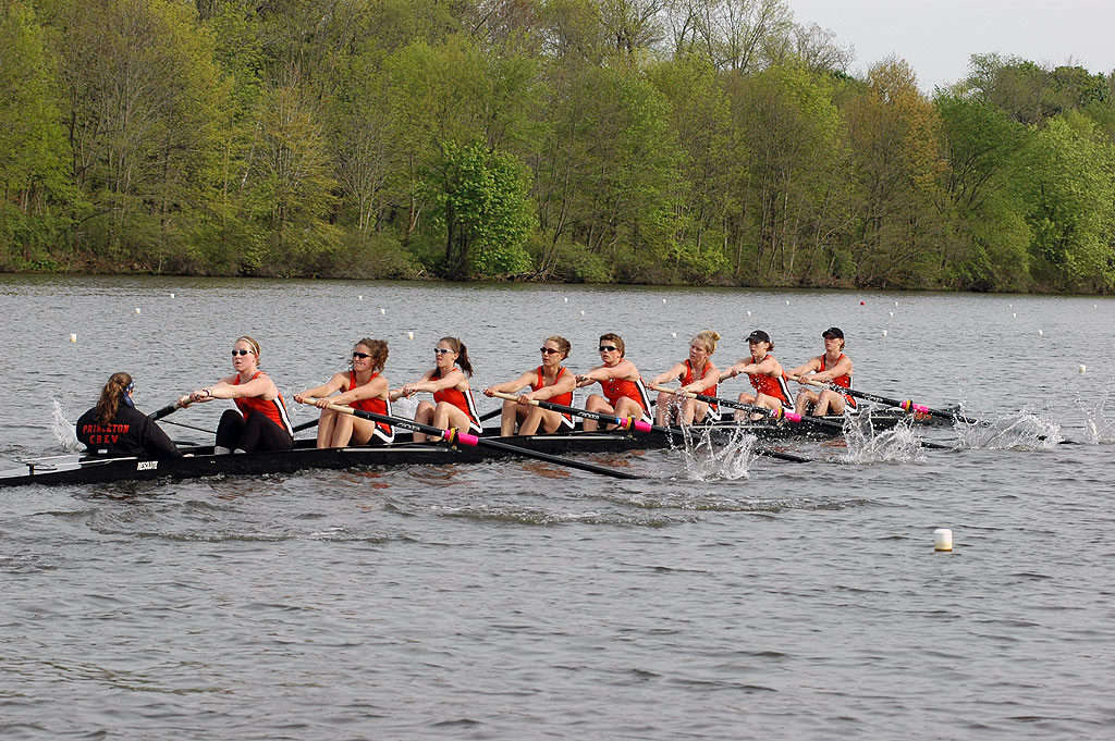 A group of people rowing a boat in a body of water