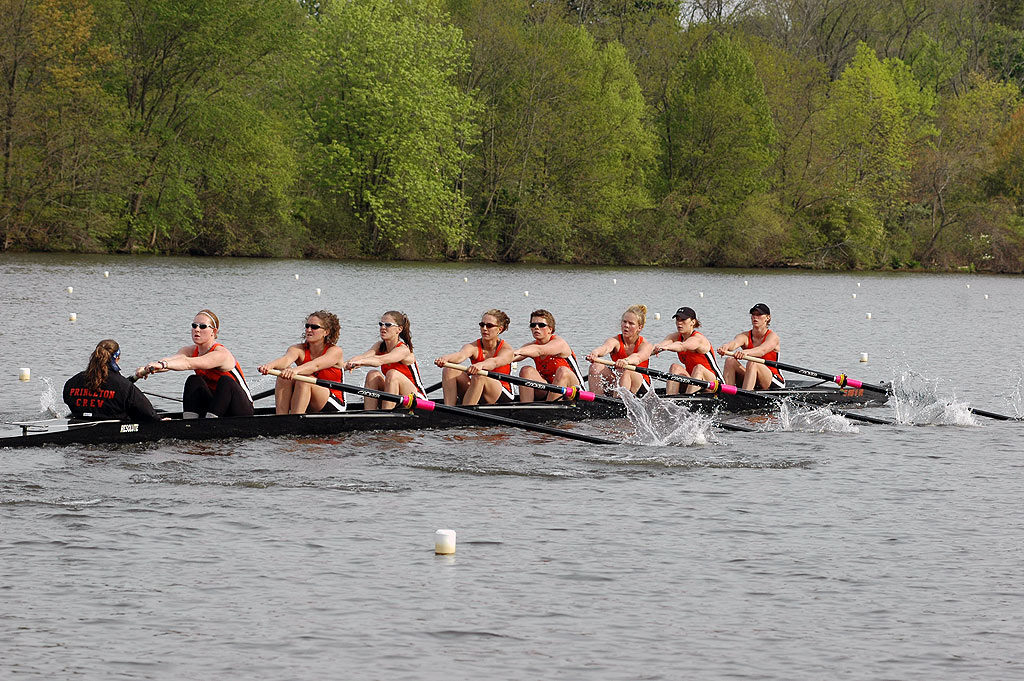 A group of people rowing a boat in a body of water