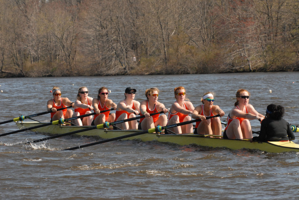 A group of people rowing a boat in the water