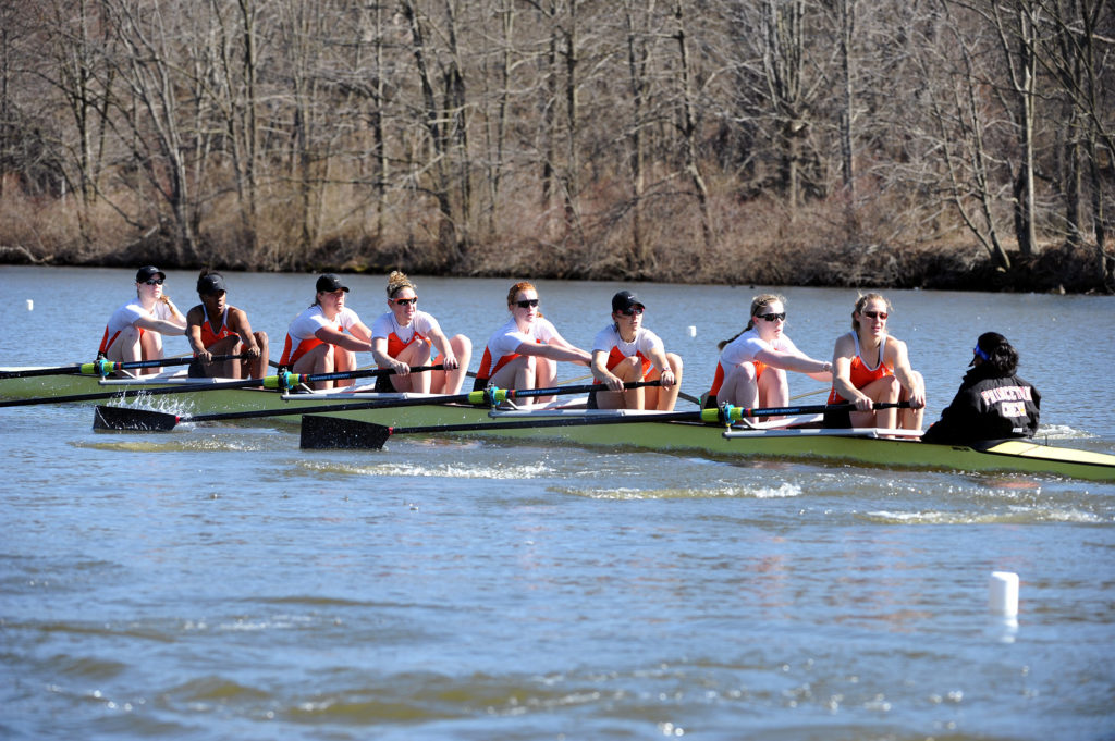 A group of people rowing a boat in the water