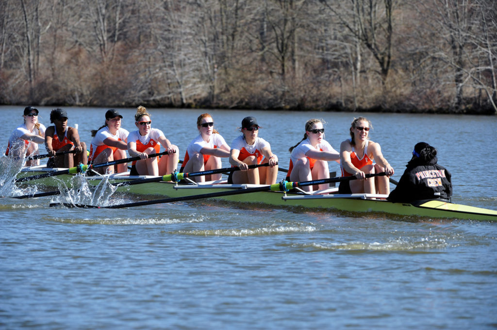 A group of people rowing a boat in the water