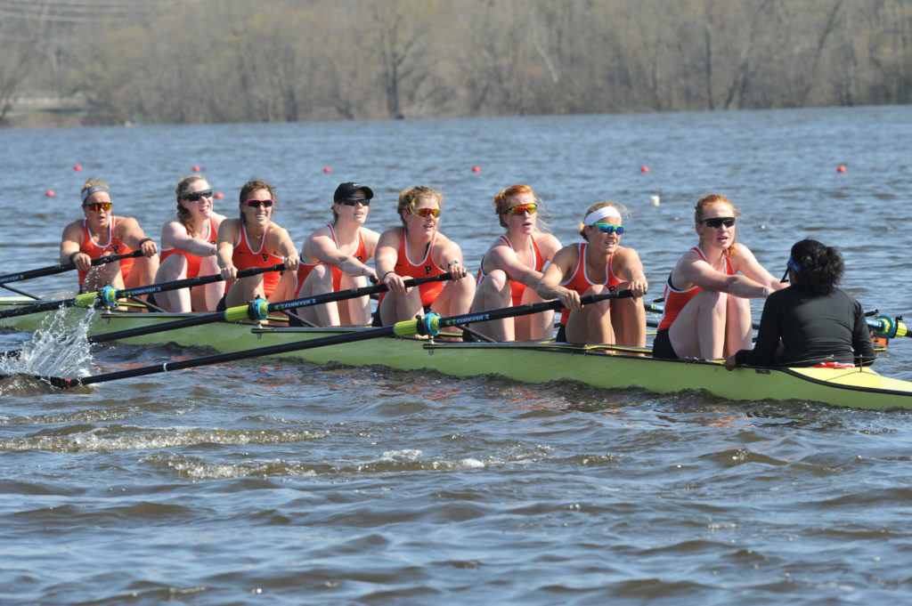 A group of people rowing a boat in the water