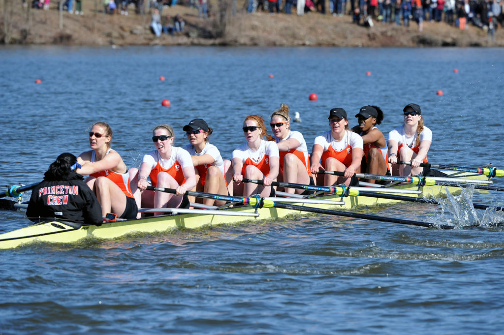 A group of people rowing a boat in the water