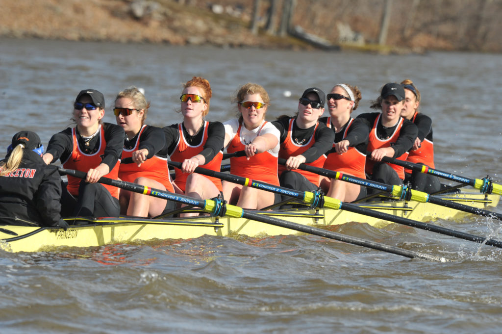 A group of people rowing a boat in the water