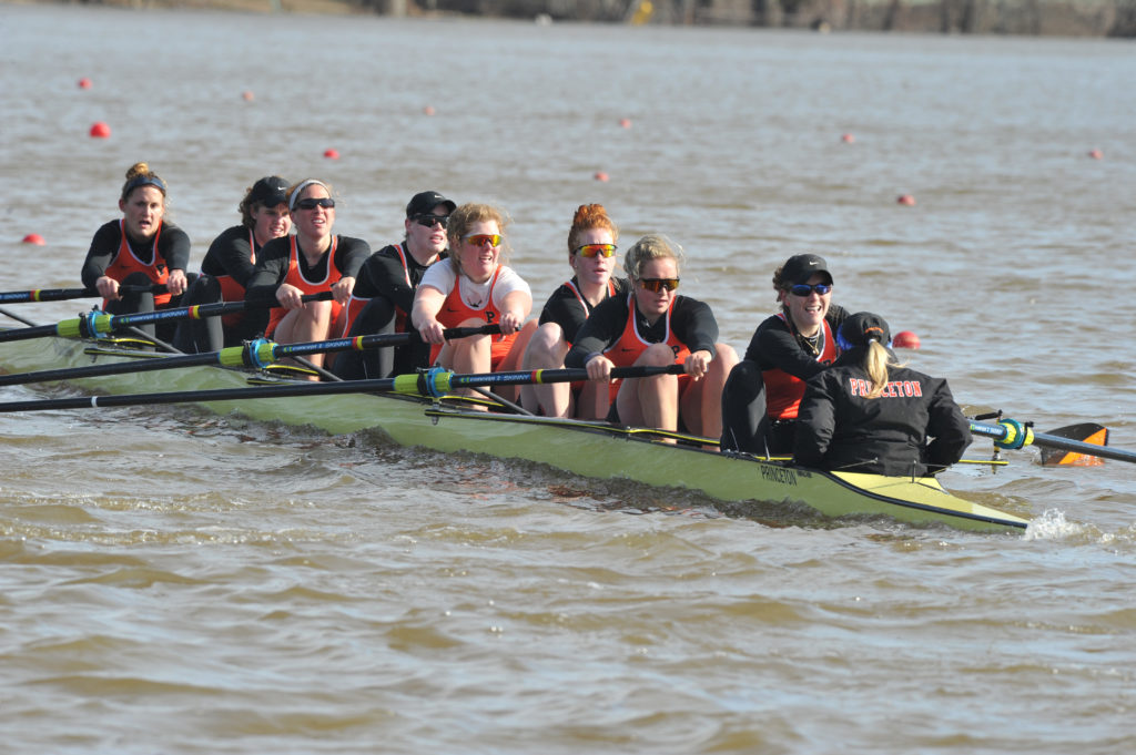 A group of people rowing a boat in the water