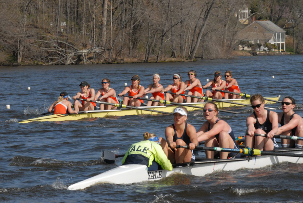 A group of people rowing a boat in a body of water