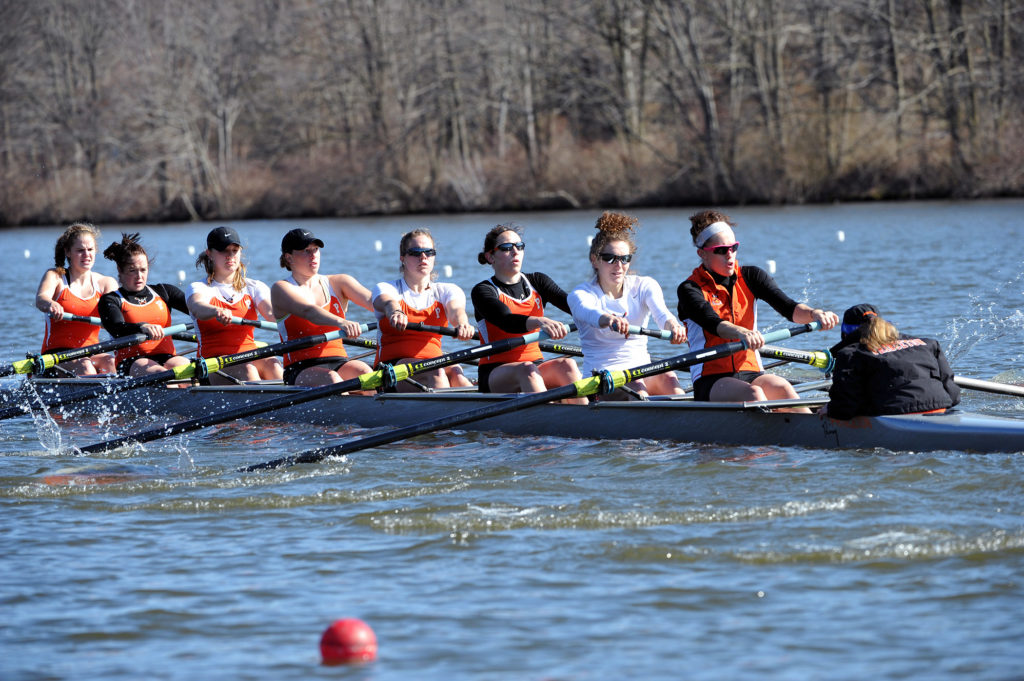 A group of people rowing a boat in the water