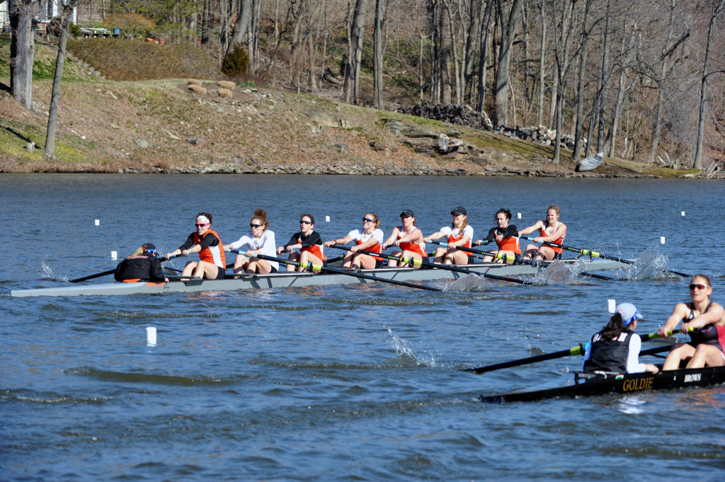 A group of people rowing a boat in the water