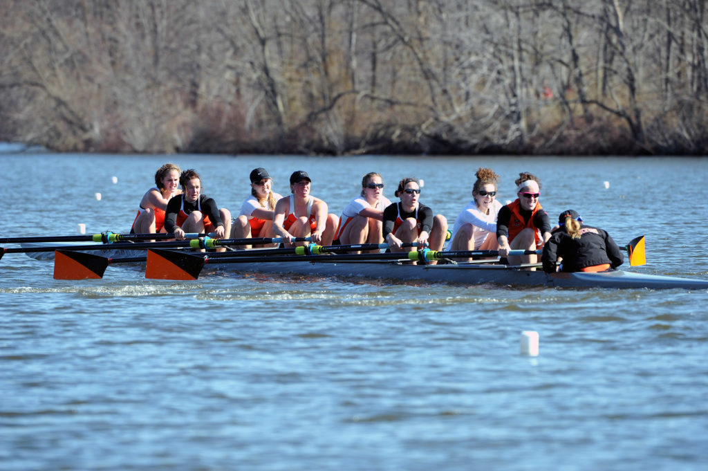 A group of people rowing a boat in a body of water