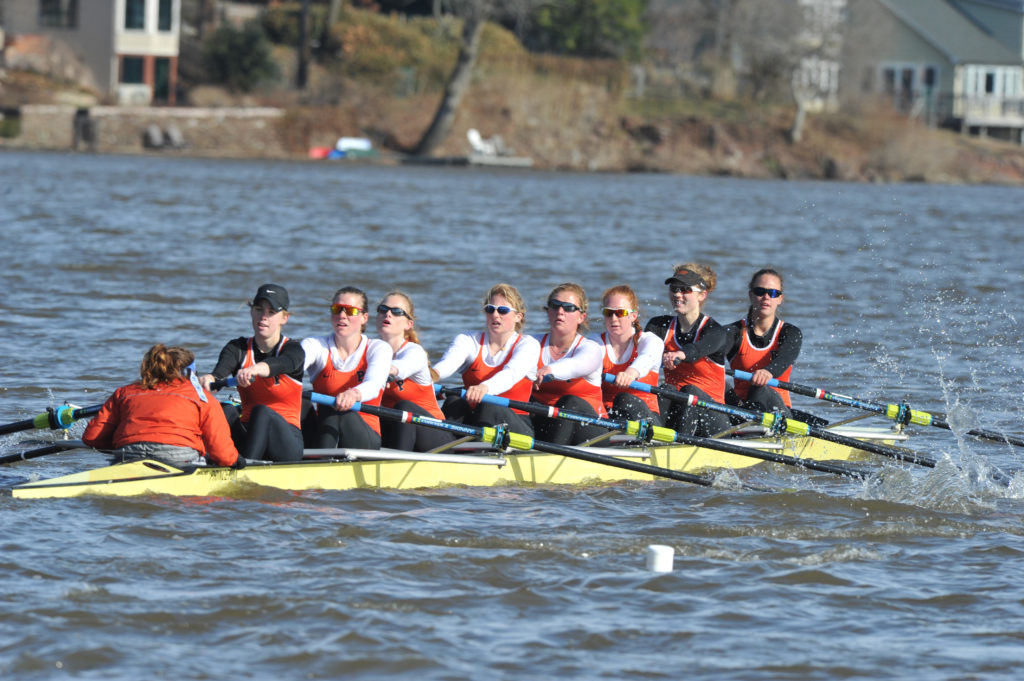 A group of people rowing a boat in a body of water